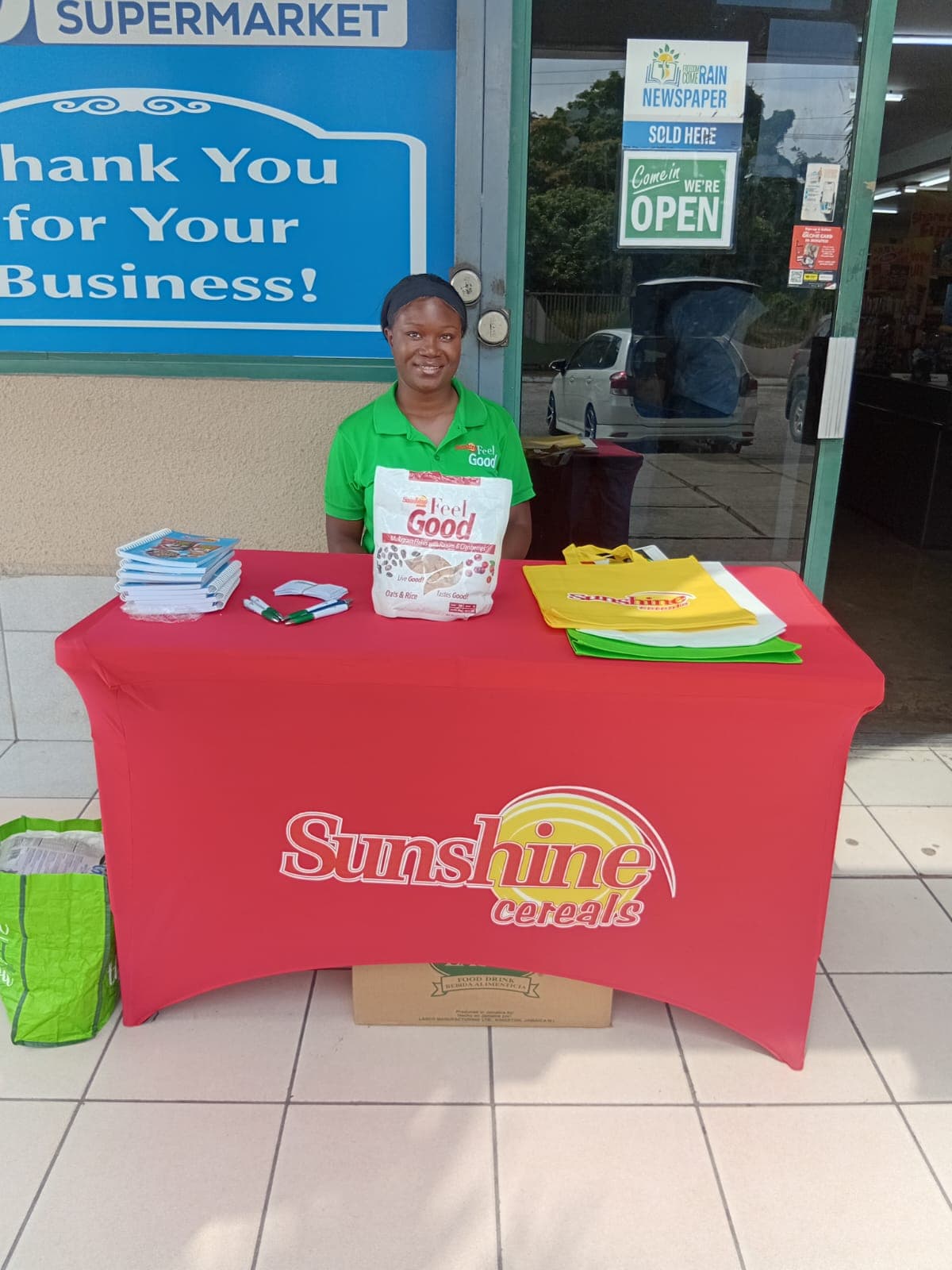 Brand ambassador at a Sunshine Feel Good supermarket sampling table.